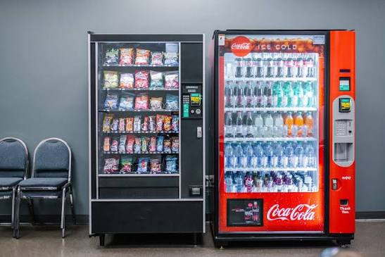 Snack machine beside a Coca-Cola cold drink vending machine